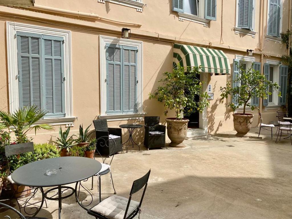 eine Terrasse mit einem Tisch und Stühlen sowie ein Gebäude in der Unterkunft Chanteclair in Cannes