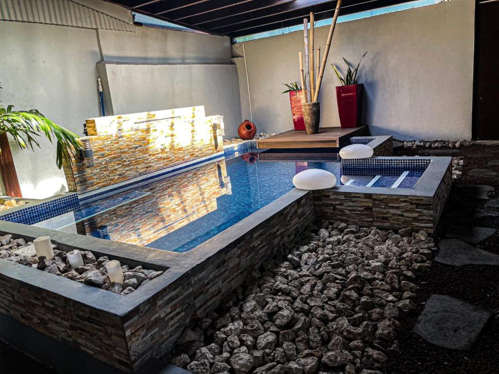 una piscina de agua con rocas en una habitación en Casa Dossman, en Puntarenas