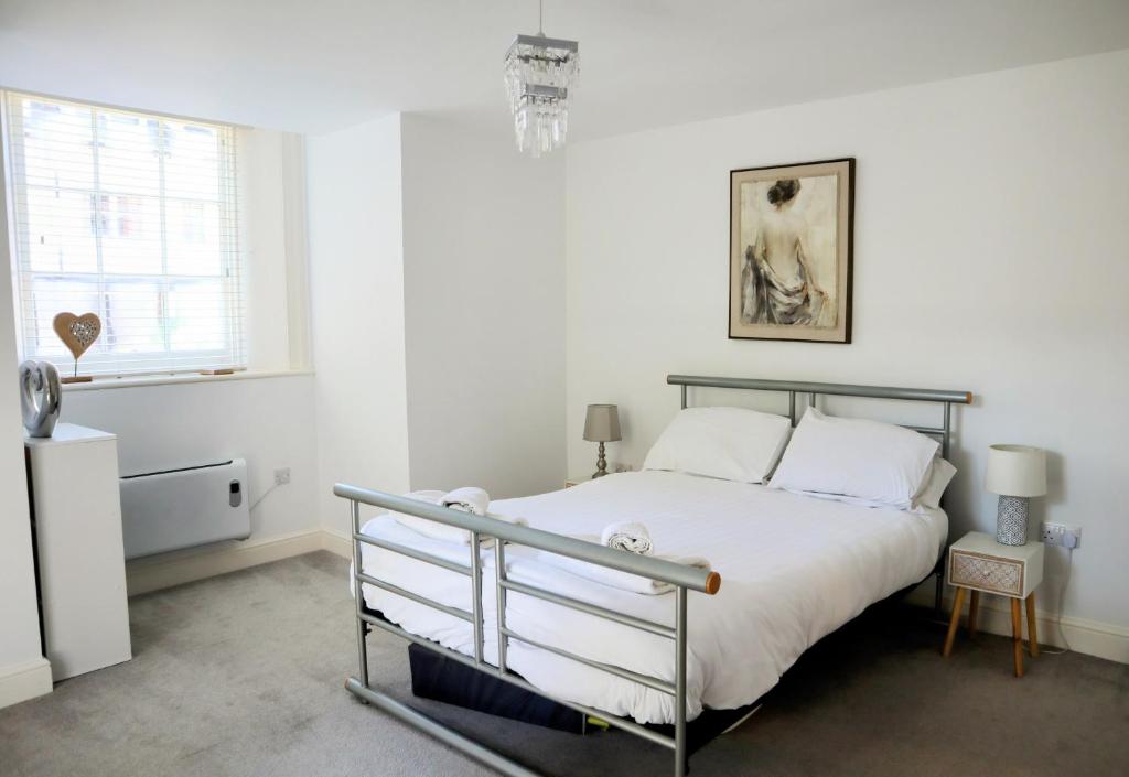 イプスウィッチにあるLuxury 2-Bed Flat Central Ipswich Parkingの白いシーツと窓のあるベッドのある寝室
