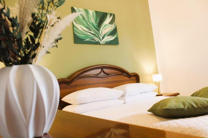 a bedroom with two beds and a vase with flowers at Casa Luisa in Pitigliano