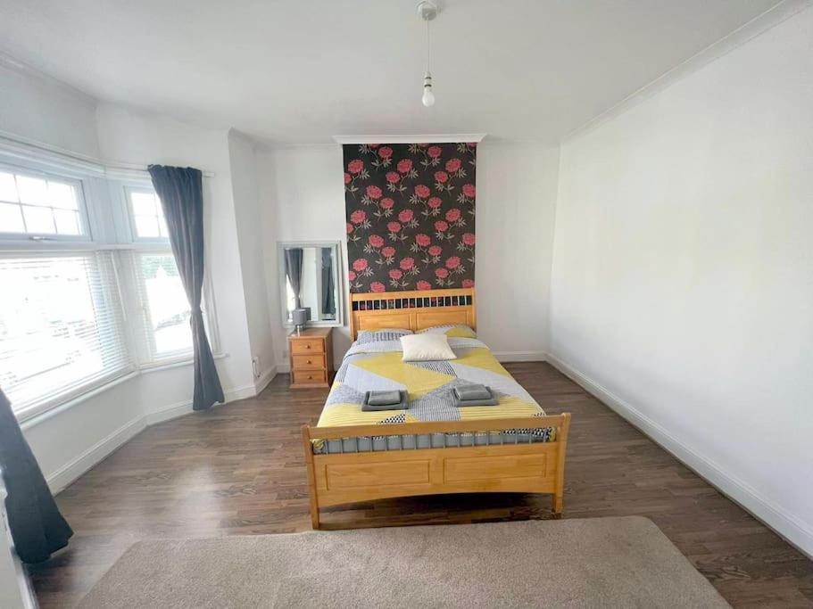 a bedroom with a wooden bed in a room at 3-bedroom house - Thornton Heath in Thornton Heath