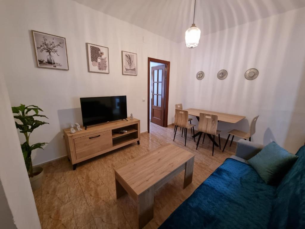 ein Wohnzimmer mit einem blauen Sofa und einem Tisch in der Unterkunft AT SAN PEDRO 2 in Olivenza