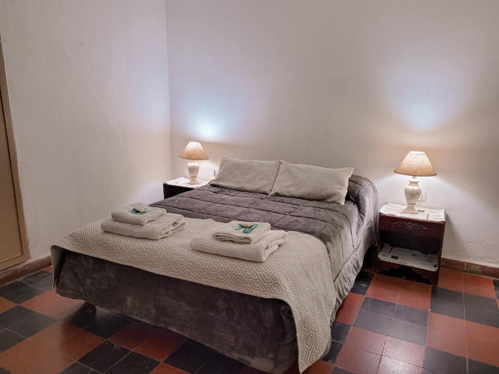 1 dormitorio con 1 cama con toallas en Cactus del Valle en Tinogasta