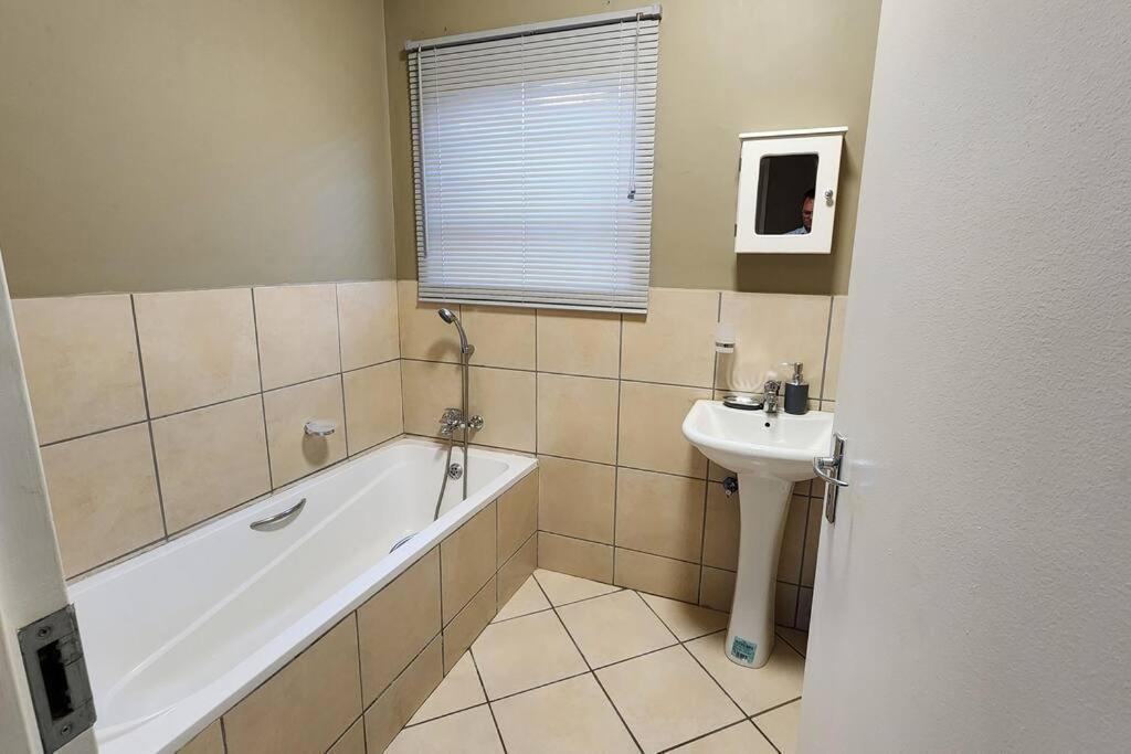 een badkamer met een bad en een wastafel bij @LloydsII in Ermelo