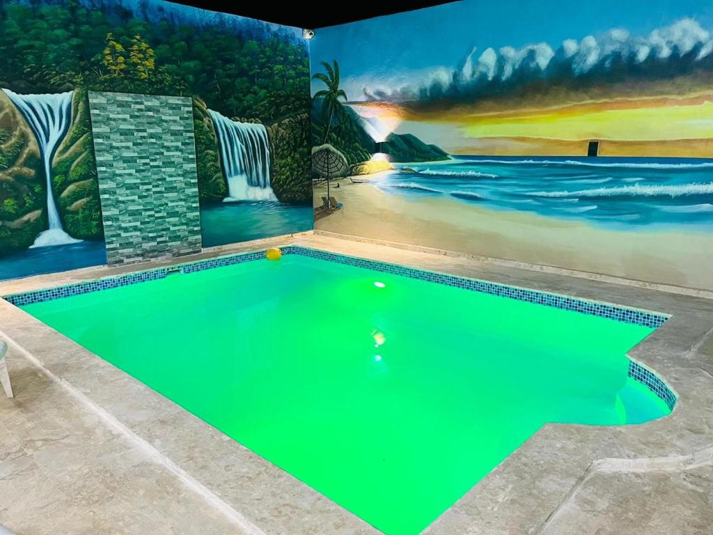 a swimming pool in a house with a painting on the wall at Complejo girasol in Santo Domingo