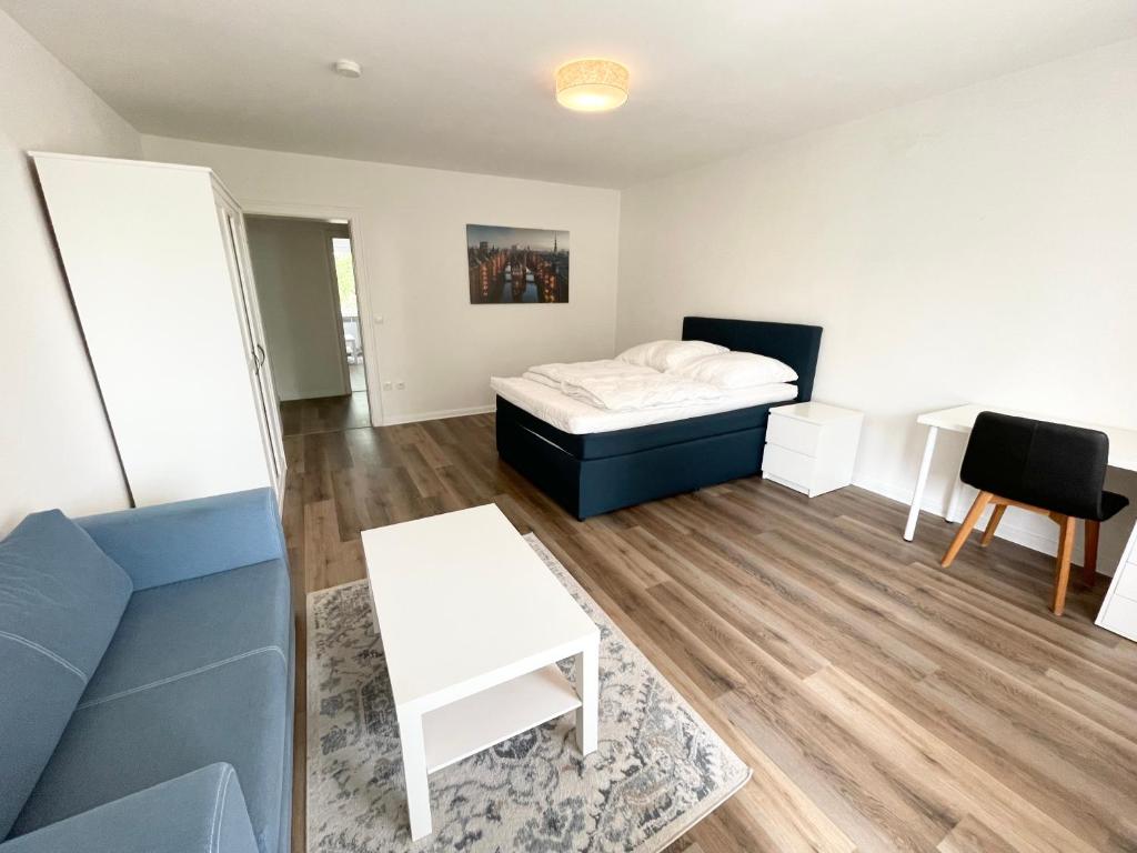 a room with a bed and a table and a couch at Zentrale Wohnung mit 3 Schlafzimmer für bis zu 9 Personen in Hamburg