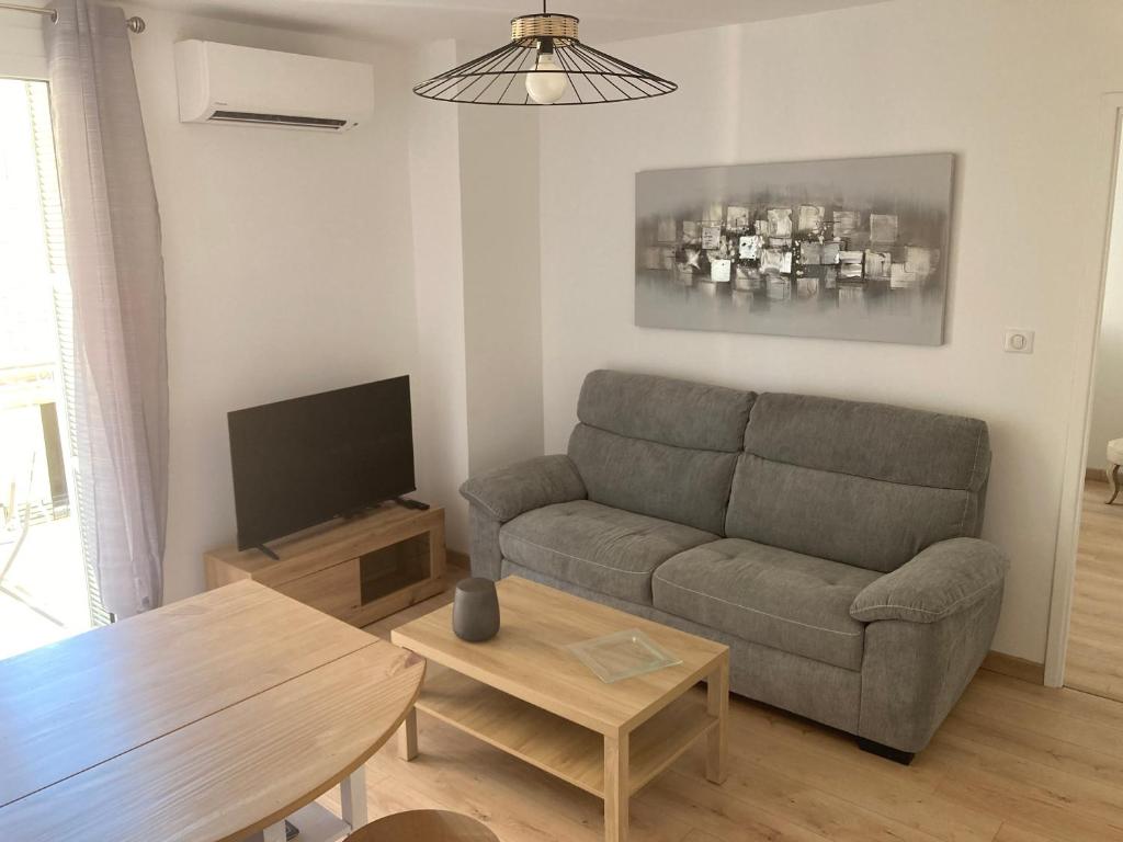 een woonkamer met een bank en een tafel bij F2 Pompeani in Ajaccio