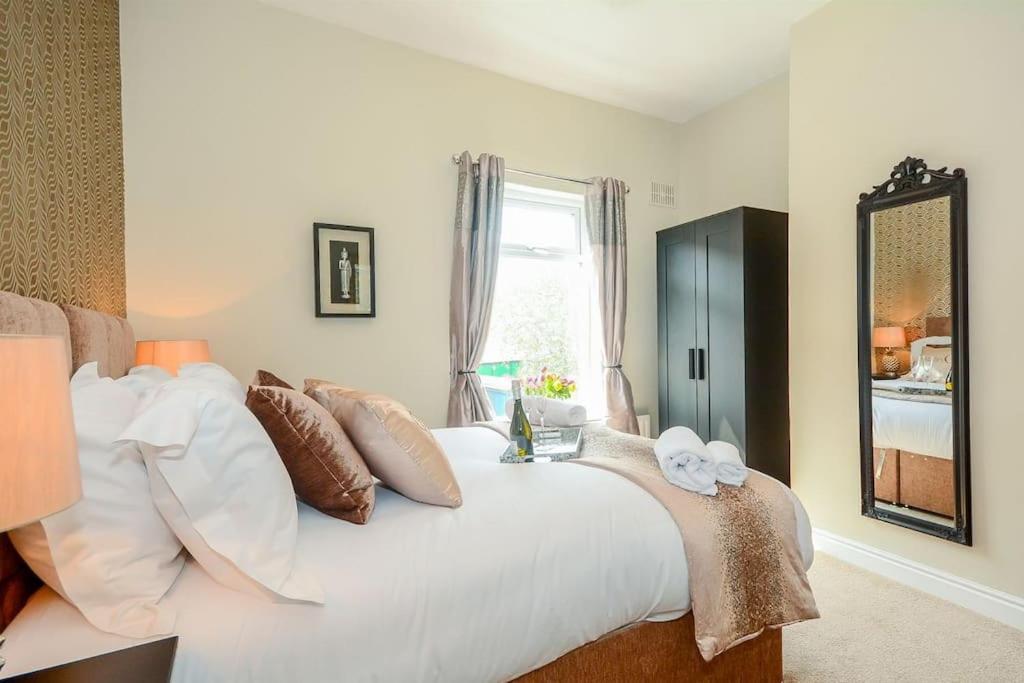 a bedroom with a white bed with pillows and a window at New - Prospect lodge , City Centre Terraced House in York