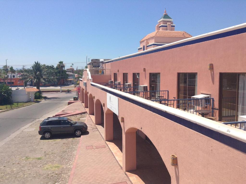 une voiture garée sur le côté d'un bâtiment dans l'établissement Los Jitos Hotel & Suites, à San Carlos