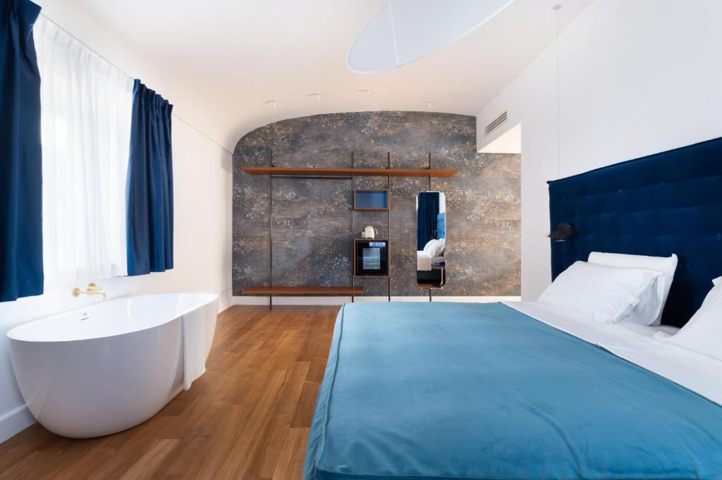 um quarto com uma cama grande e uma banheira em Palazzo Martinelli em Sorrento