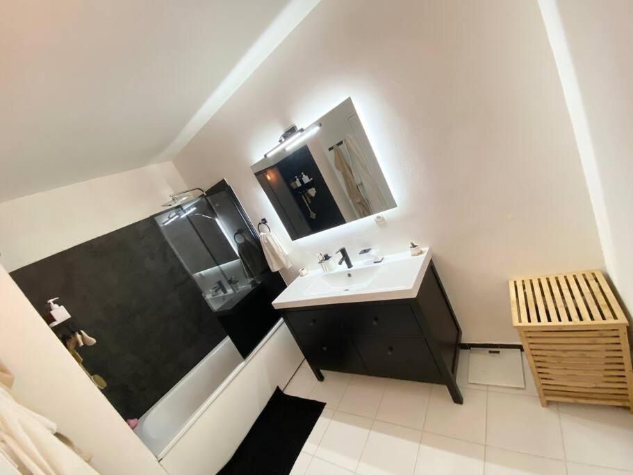 a white bathroom with a sink and a shower at Appartement avec deux balcons in Magny-les-Hameaux