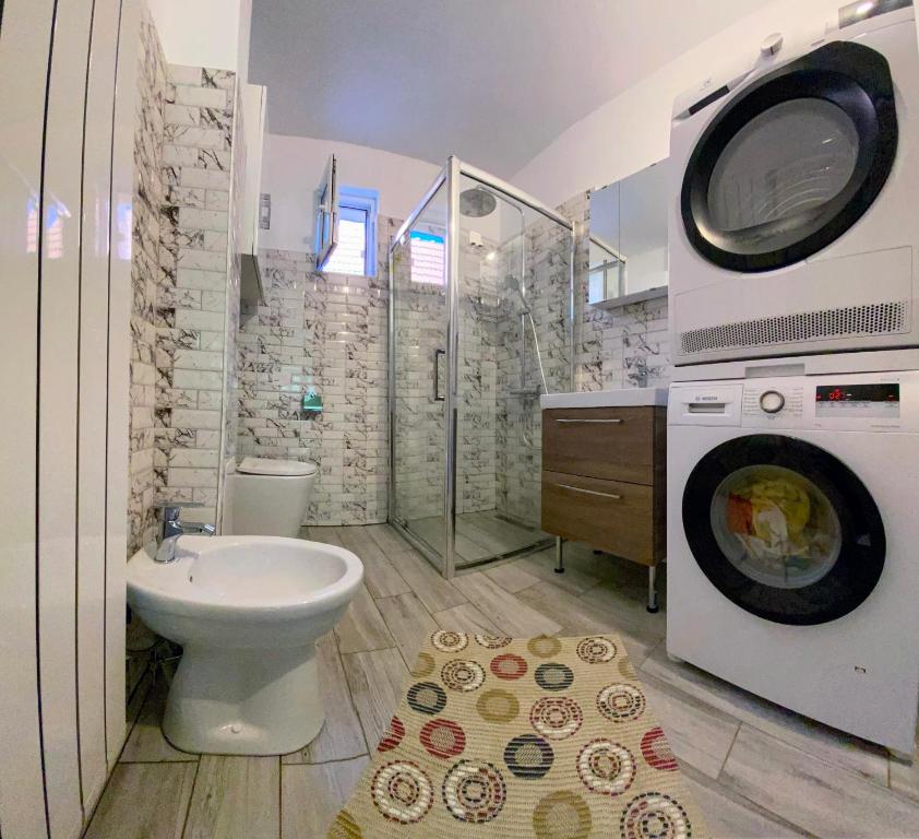 a bathroom with a toilet and a washing machine at Casa Popa in Cîrţişoara