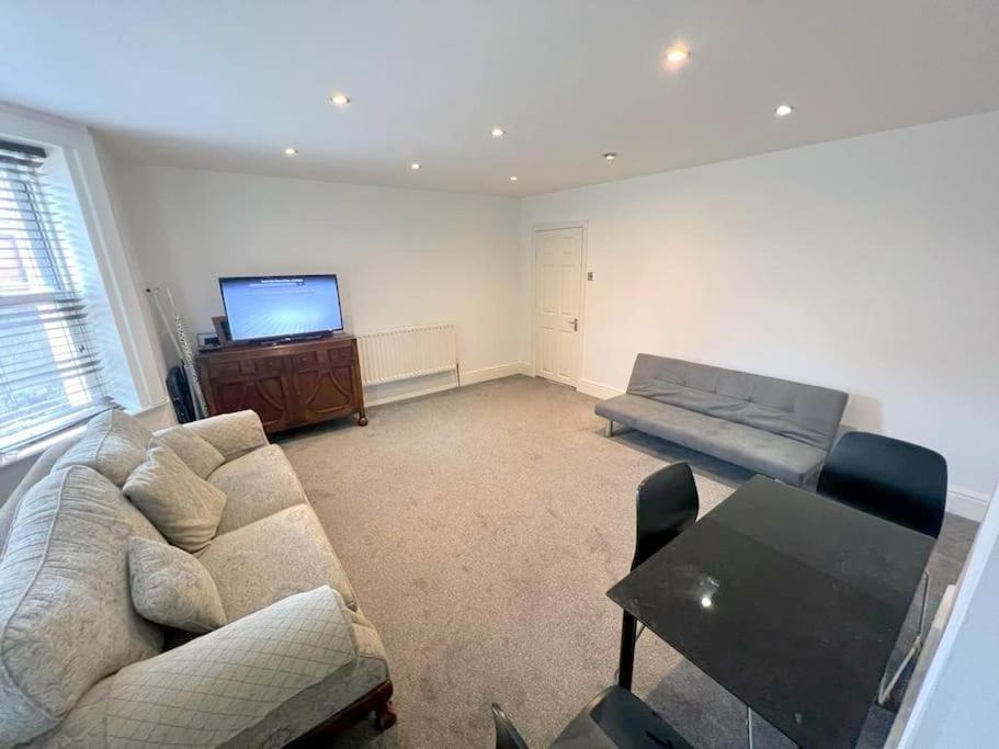 a living room with a couch and a television at Spacious 1-bedroom Flat in Sutton (South London) in Sutton