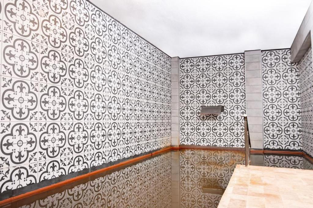 a bathroom with black and white tiles on the wall at Ladik Hotel in Karahayit