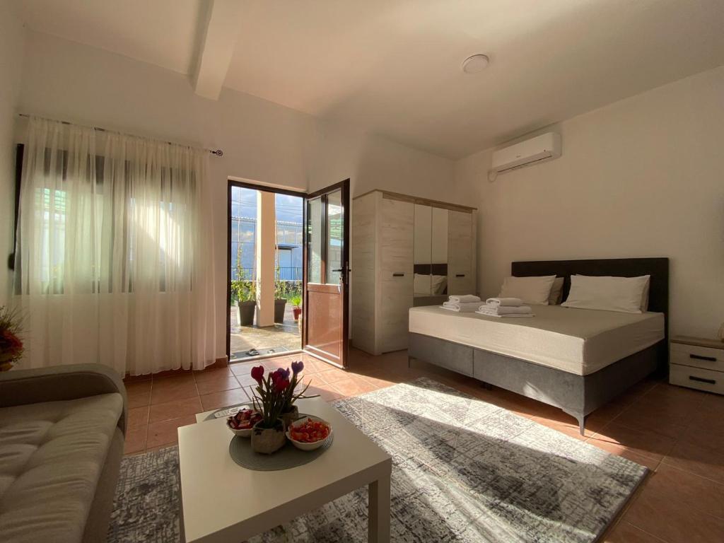 a bedroom with a bed and a living room at Olive apartment in Podgorica