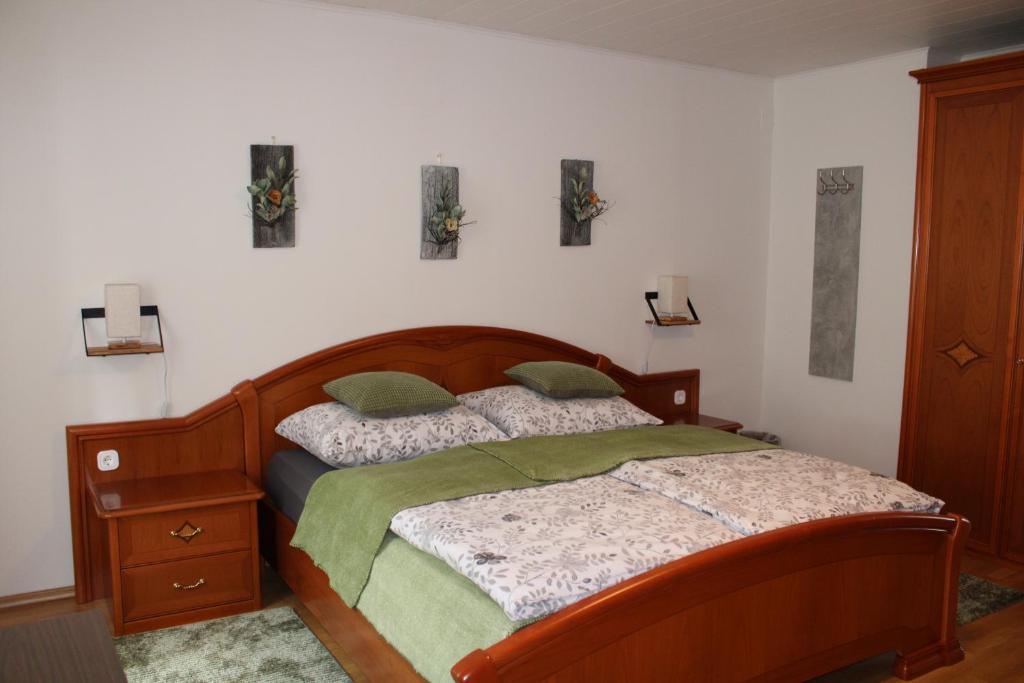 um quarto com uma cama de madeira e 2 almofadas em Blütenhof Apartment "Zur inneren Balance" em Bad Radkersburg