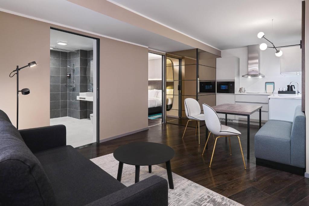 ein Wohnzimmer mit einem Sofa und einem Tisch sowie eine Küche in der Unterkunft Residence Inn by Marriott Essen City in Essen