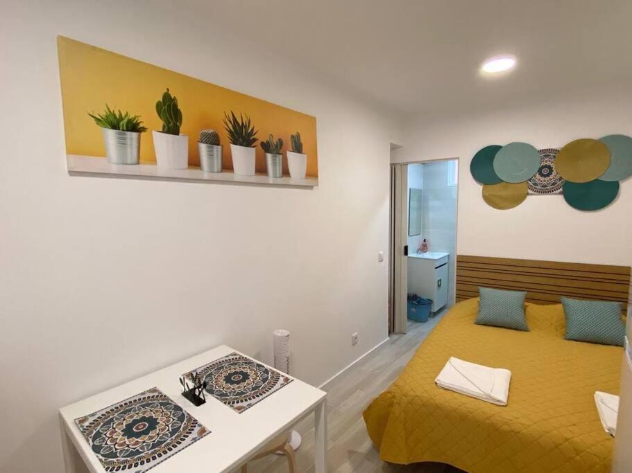 a bedroom with a yellow bed and a table at Holiday Setúbal Loft in Setúbal