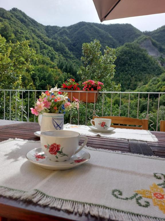 una mesa con una taza de café y flores. en B&B Donnini Firenzuola, en Casetta di Tiara
