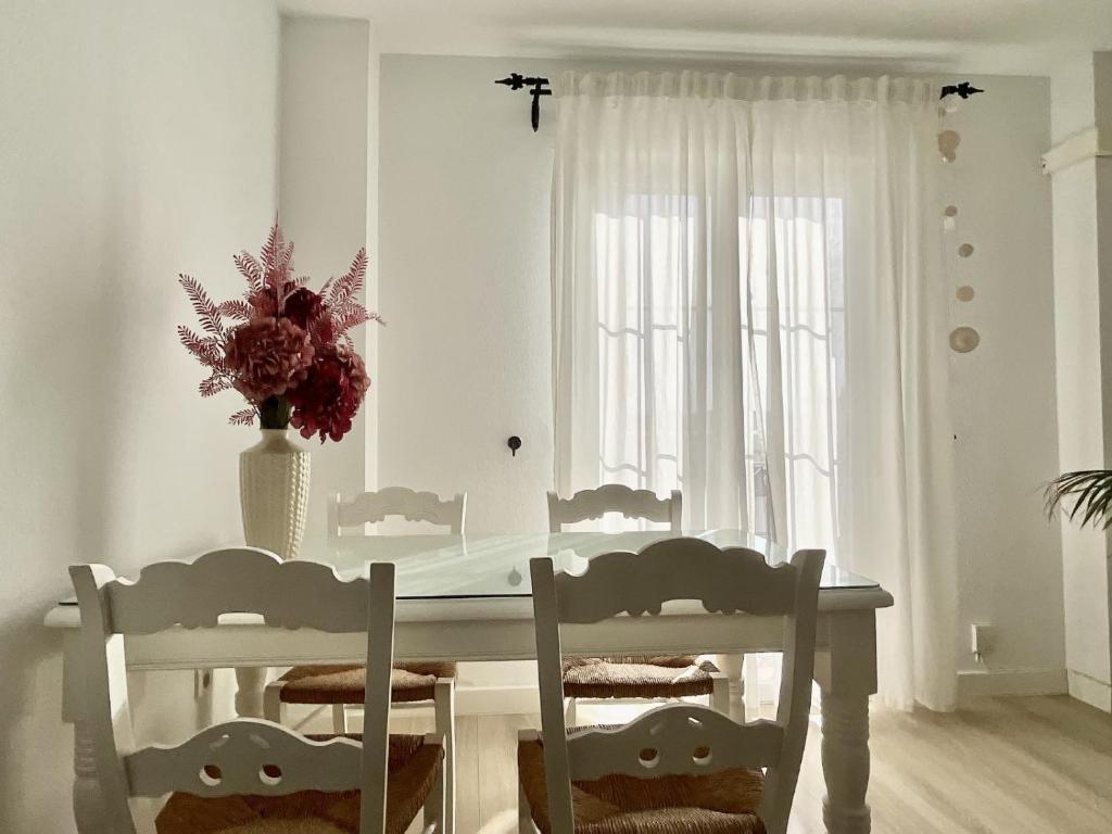 een witte eetkamer met een witte tafel en stoelen bij Apartamento Ronda Centro in Ronda