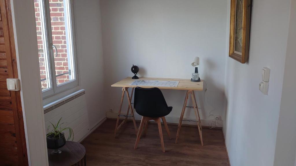 een bureau met een stoel in een kamer met een raam bij La Symphorine in Grandvilliers