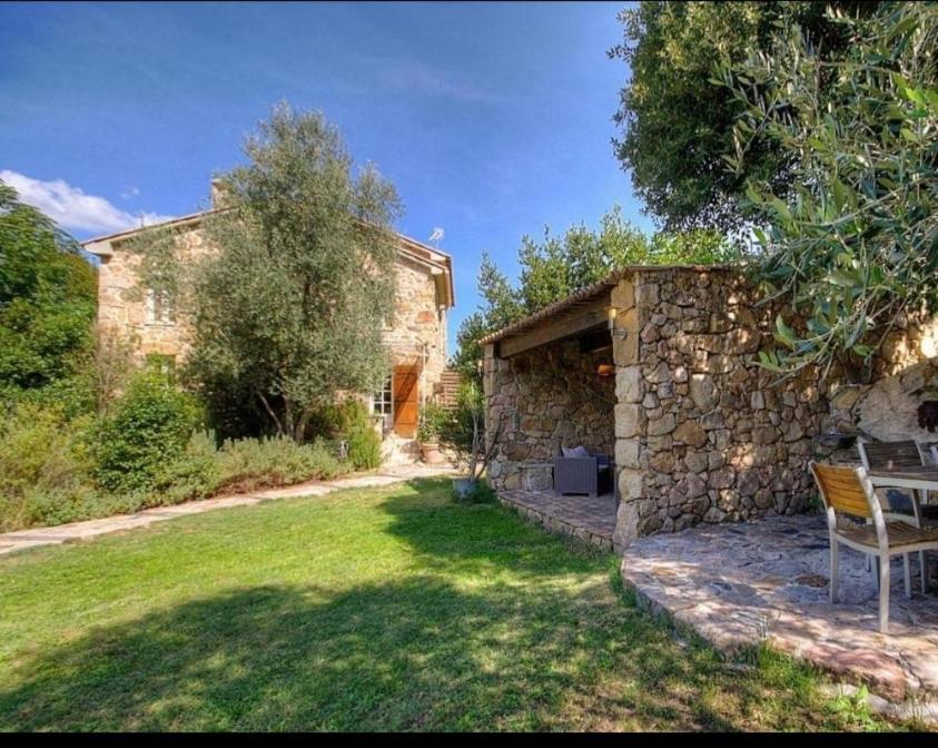 a stone house with a table in a yard at Résidence A CASA VECCHIA gites de charme avec JACUZZI proche Ajaccio in Peri