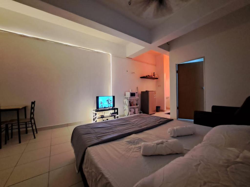 ein Schlafzimmer mit einem großen Bett und einem TV in der Unterkunft LED Homestay in Shah Alam