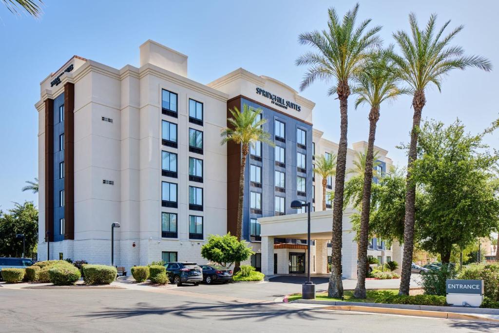 a hotel with palm trees in front of a building at SpringHill Suites Phoenix Downtown in Phoenix