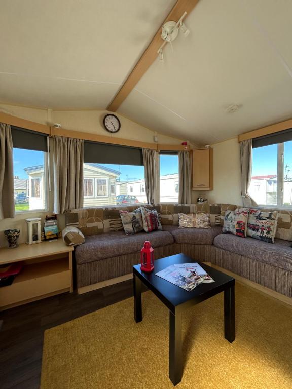 a living room with a couch and a table at Lyons Robin Hood Coastal Holiday Park, Savannah in Rhyl