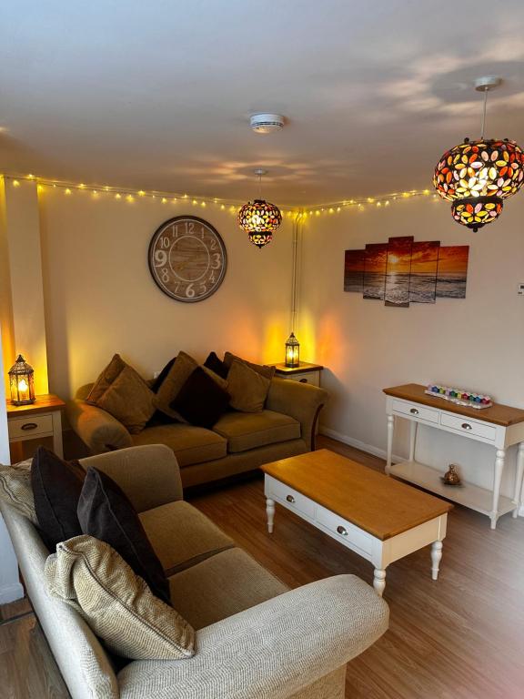 a living room with a couch and a table at Cosy Herne Bay Seaside Cottage in Kent