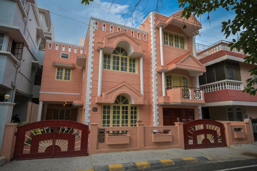 een roze gebouw met een hek ervoor bij HomeSlice Nazaara, HomeStay in BTM in Bangalore