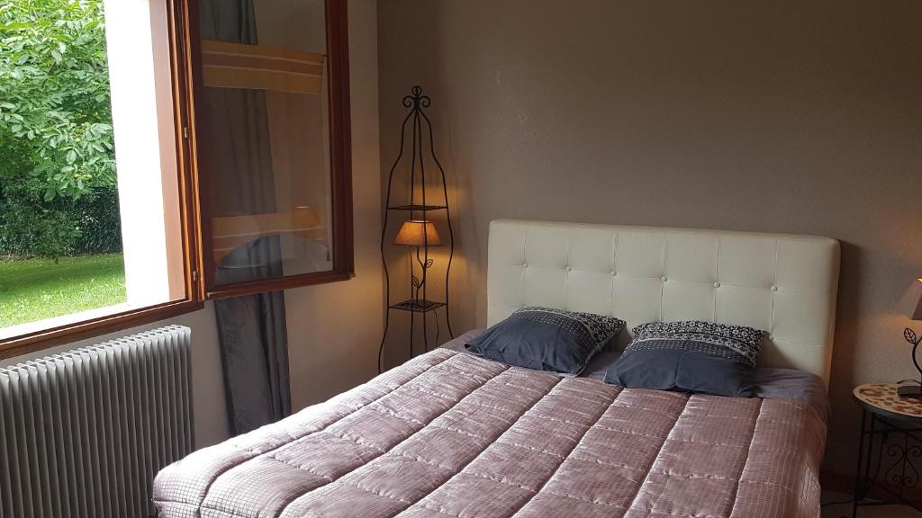 a bedroom with a large bed and a window at DETENTE NATURE rando, ski , thermes in Allevard