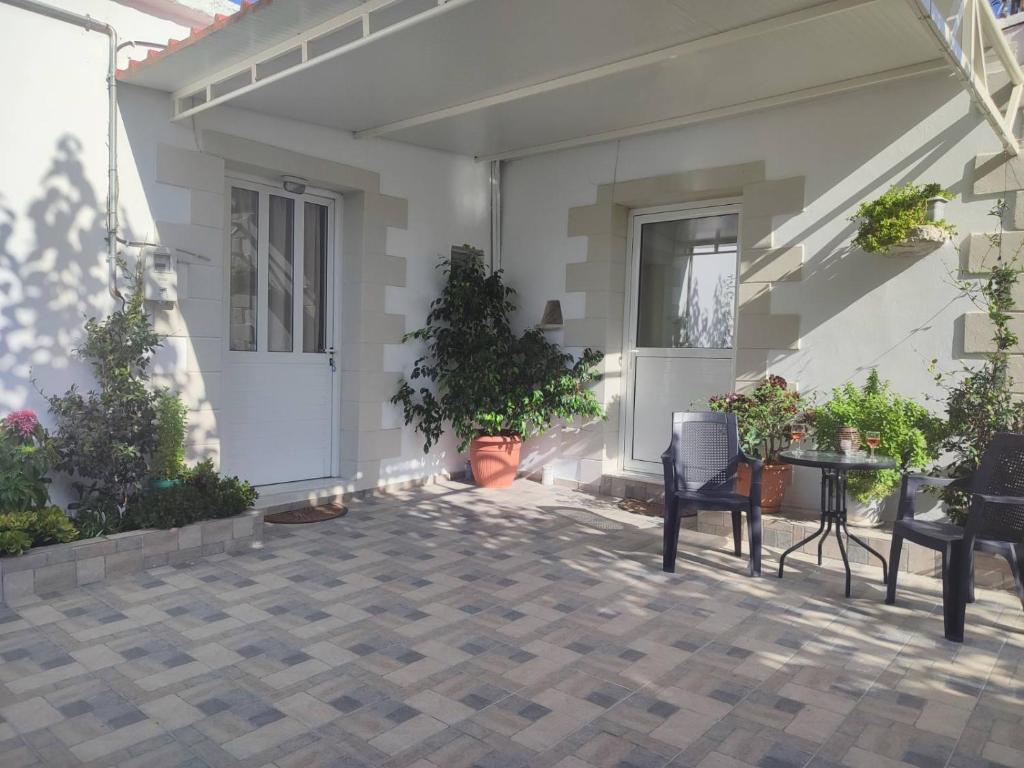 a patio with plants and a table and chairs at Yannis apartments in Georgioupolis