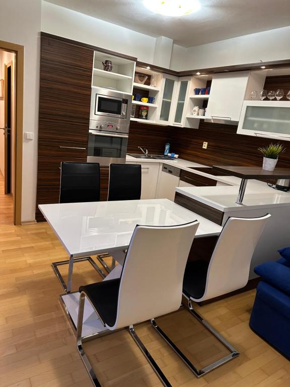 a kitchen with a white table and chairs at Apartments Spačilova nearly center in Komárov