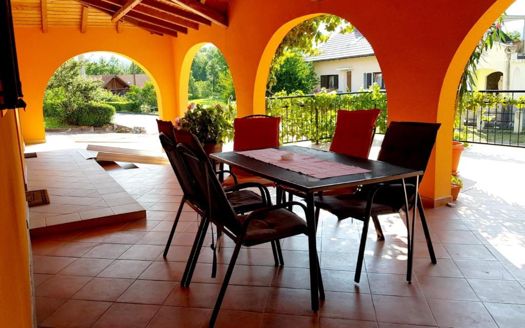 einen Tisch und Stühle auf einer Terrasse mit orangefarbener Wand in der Unterkunft 4 you in Lovinac