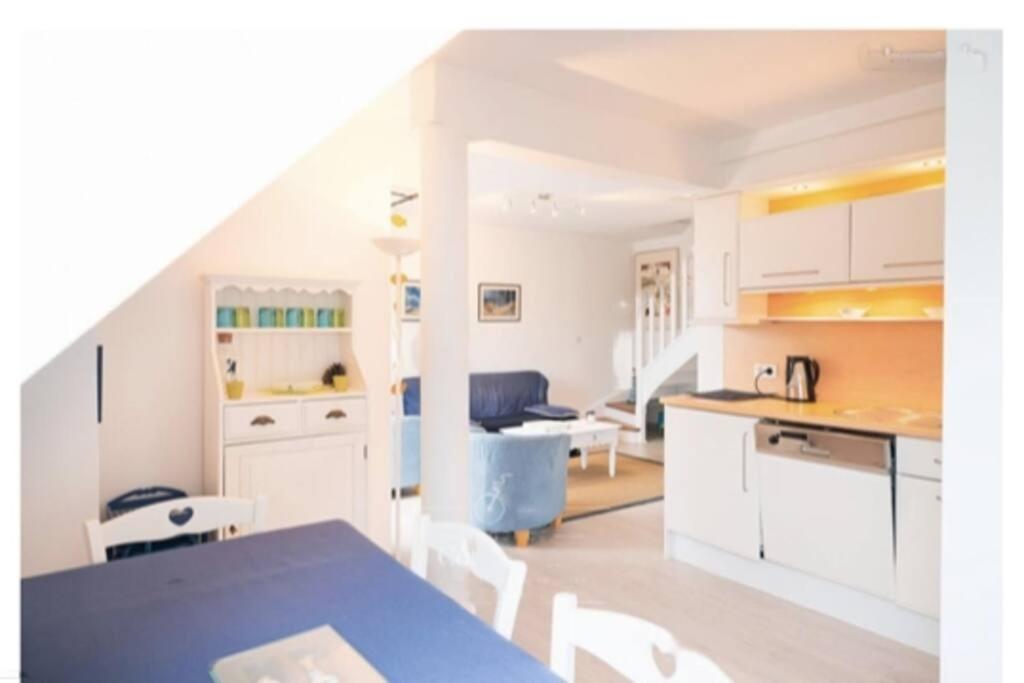 una cucina e un soggiorno con tavolo e sedie blu di Appart duplex hypercentre 8 pers , petite vue mer a Le Touquet-Paris-Plage