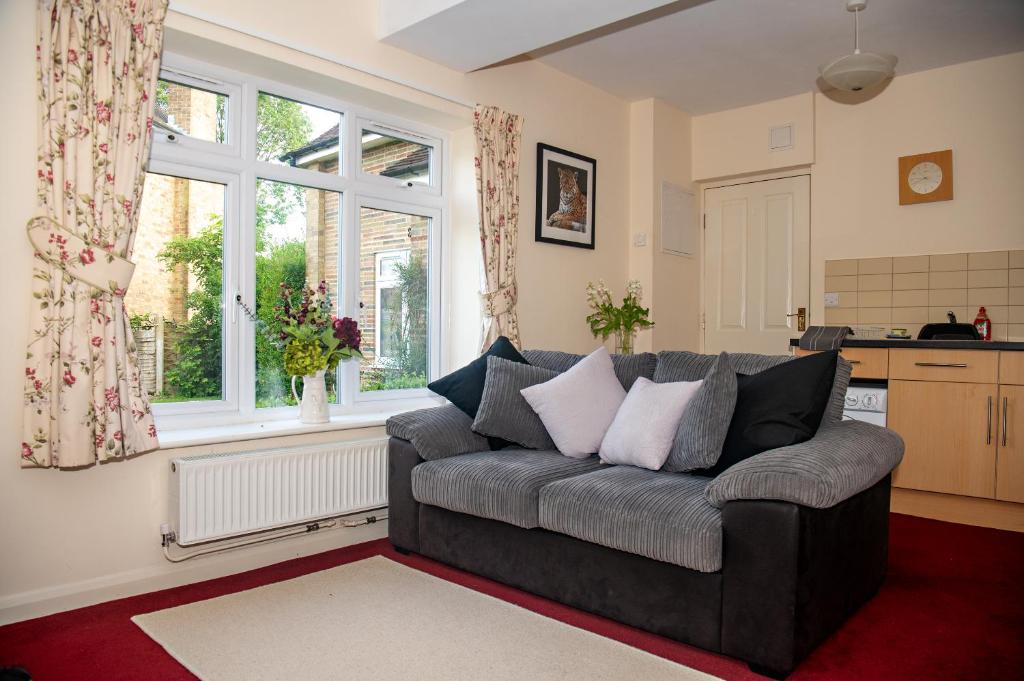 un soggiorno con divano di fronte a una finestra di Entire apt. quiet area near Leeds Castle Maidstone a Harrietsham