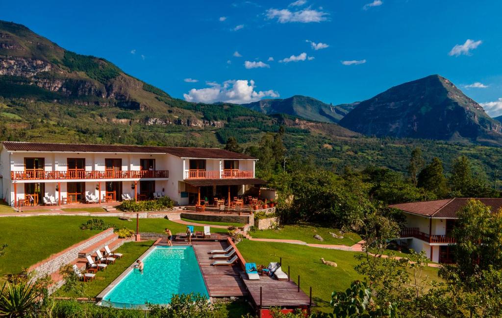 a resort with a pool and mountains in the background at Gocta Andes Lodge in Cocachimba