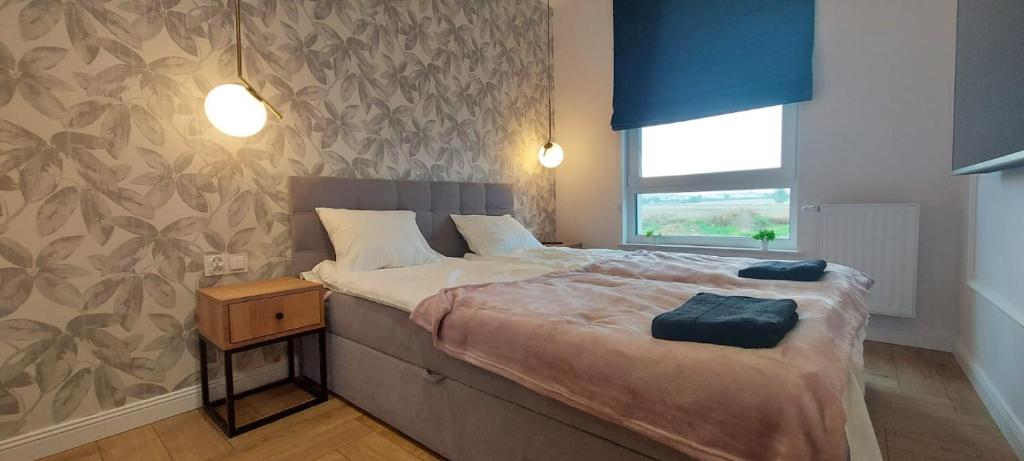 ein Schlafzimmer mit einem großen Bett und einem Fenster in der Unterkunft Kameralny Apartament nieopodal Gdyni parking NEW in Pogórze