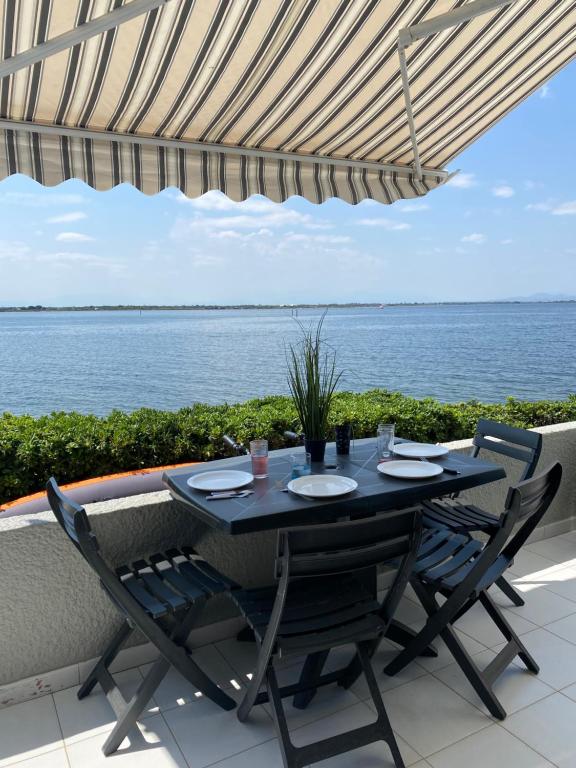 une table et des chaises sur une terrasse avec vue sur l'océan dans l'établissement Appartement-Maison 2 chambres vue exceptionnelle, au Barcarès