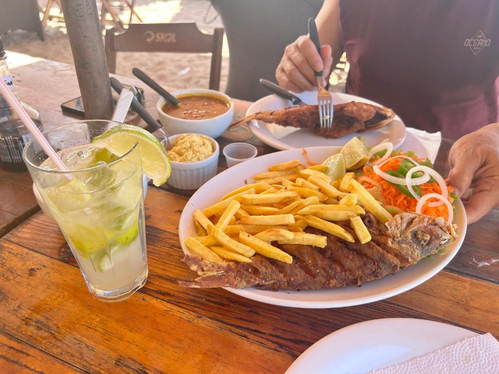 a table with a plate of food and french fries at La casa de Luna in Guaibim
