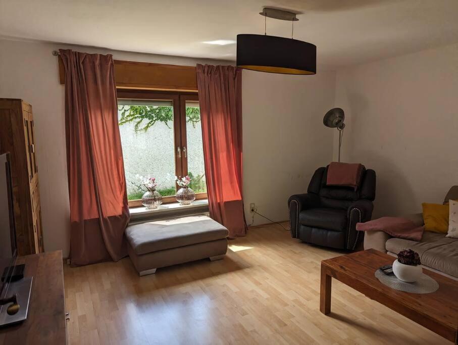 a living room with a couch and a chair and a window at Heufelsen Ferienwohnung in Hinterweidenthal