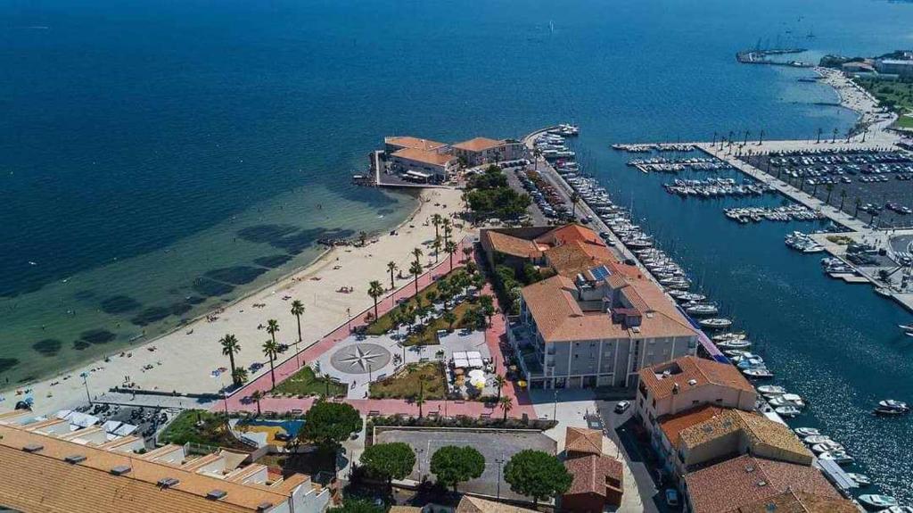 une vue aérienne d'une plage avec des bateaux dans l'eau dans l'établissement La petite OLLY, à Mèze