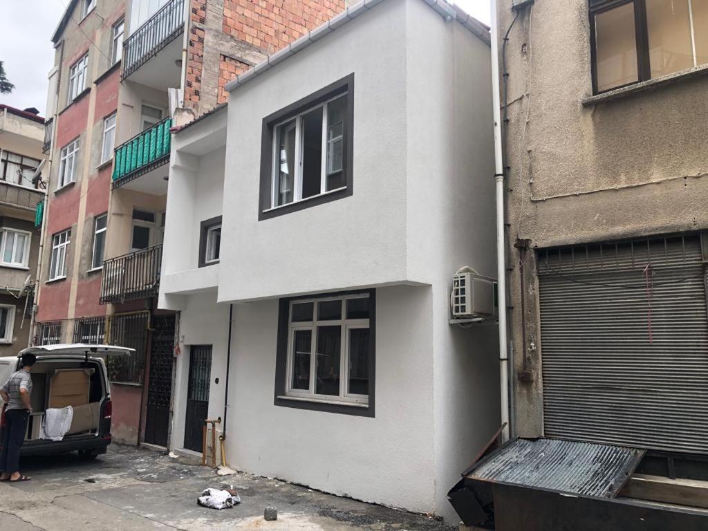 a white building with a door on a street at MEYDANDA 1+1 DAİRE in Trabzon