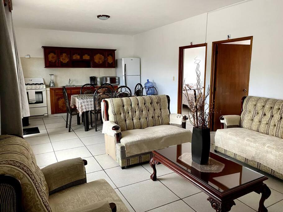 sala de estar con 2 sofás y cocina en Departamento para seis personas en Etzatlán. en Etzatlán