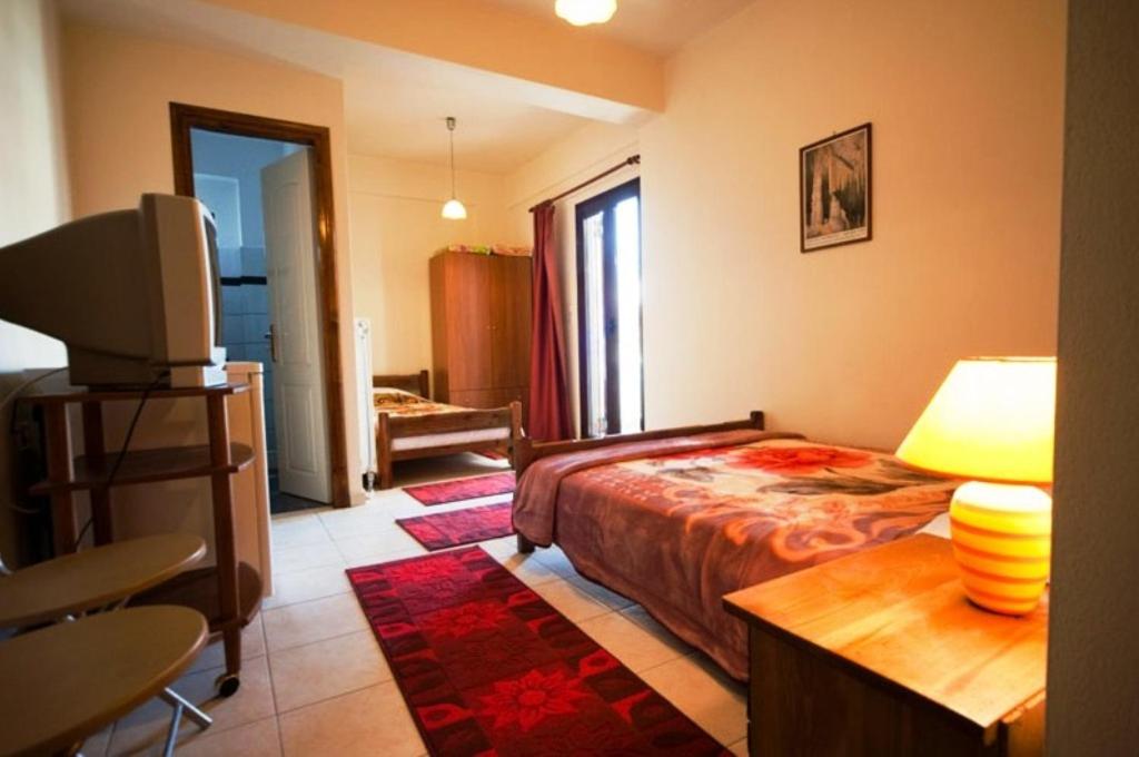 1 dormitorio con 1 cama, TV y mesa en Pavlou Rooms, en Ioannina