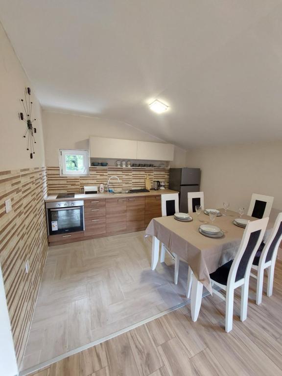 a kitchen and dining room with a table and chairs at Superb Apartments Virpazar in Virpazar