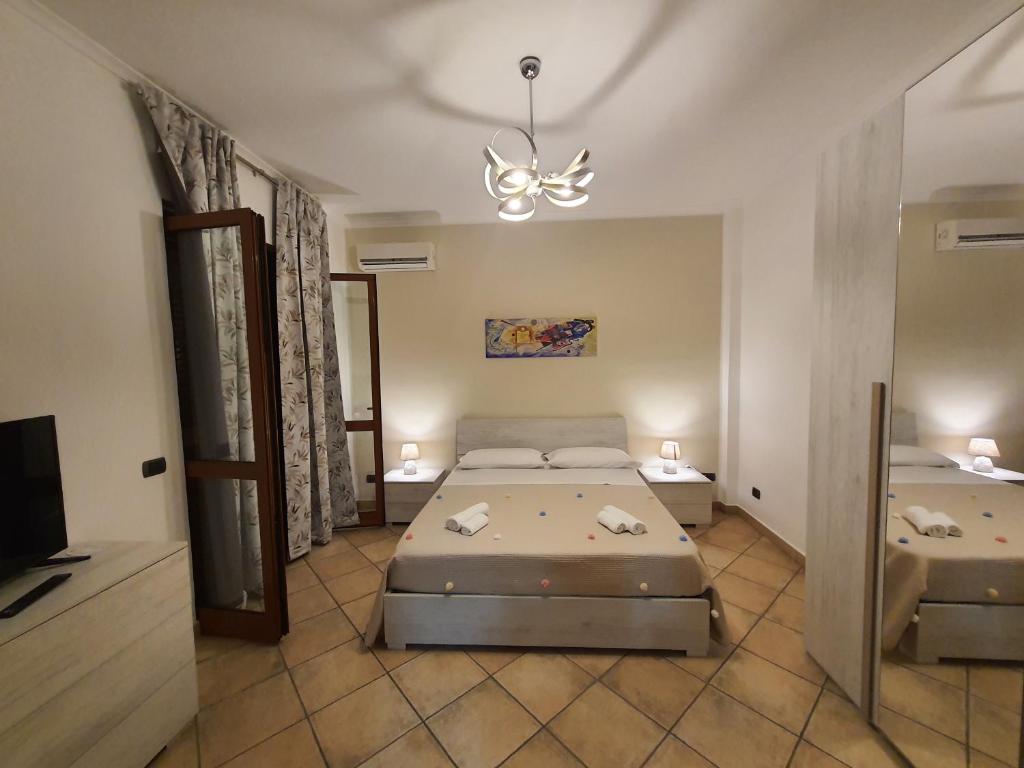 1 dormitorio con 2 camas y lámpara de araña en Maison Mael, en Scafati