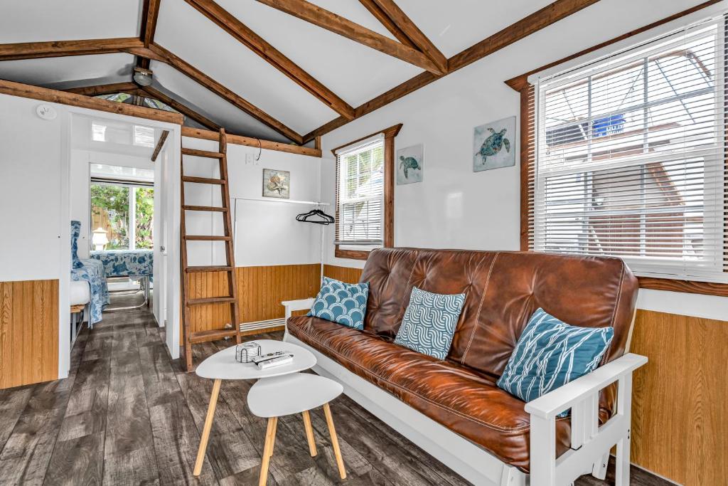 uma sala de estar com um sofá de couro e uma mesa em Treasure Harbor em Islamorada