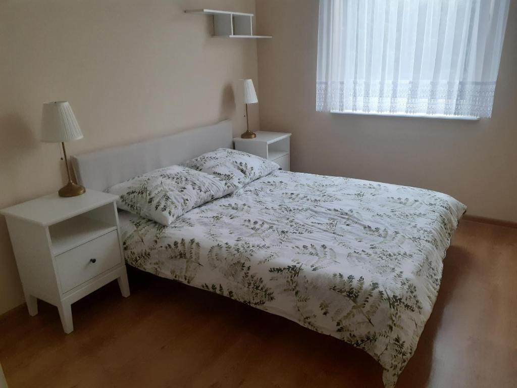 a small bedroom with a bed and a night stand at Słoneczny apartament z małym ogródkiem in Wejherowo